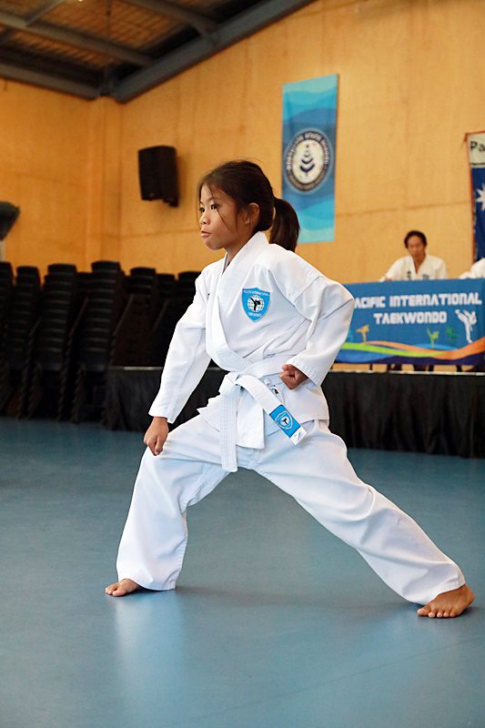 young girl takes defensive taekwondo stance