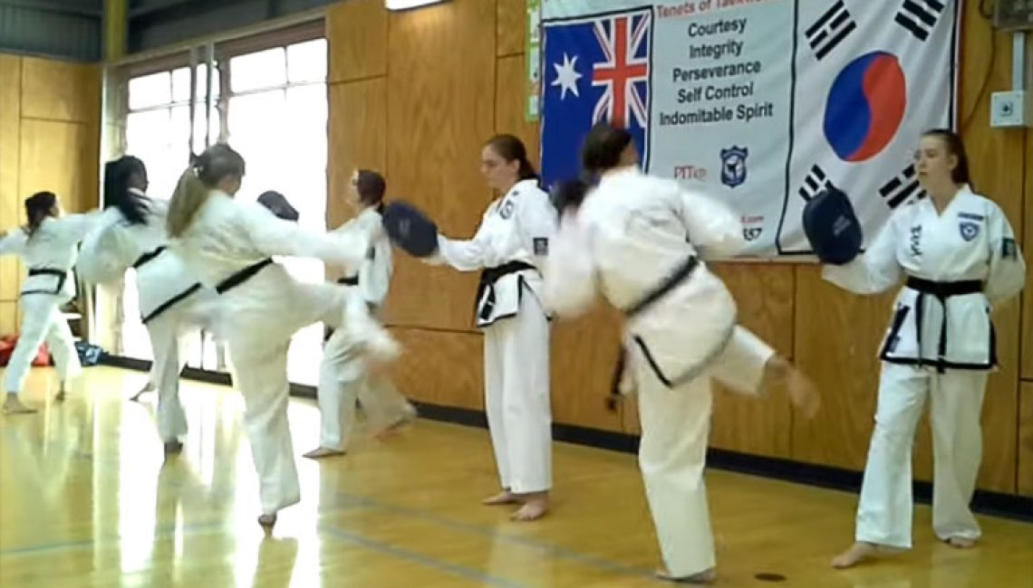 girls practice taekwondo kicks